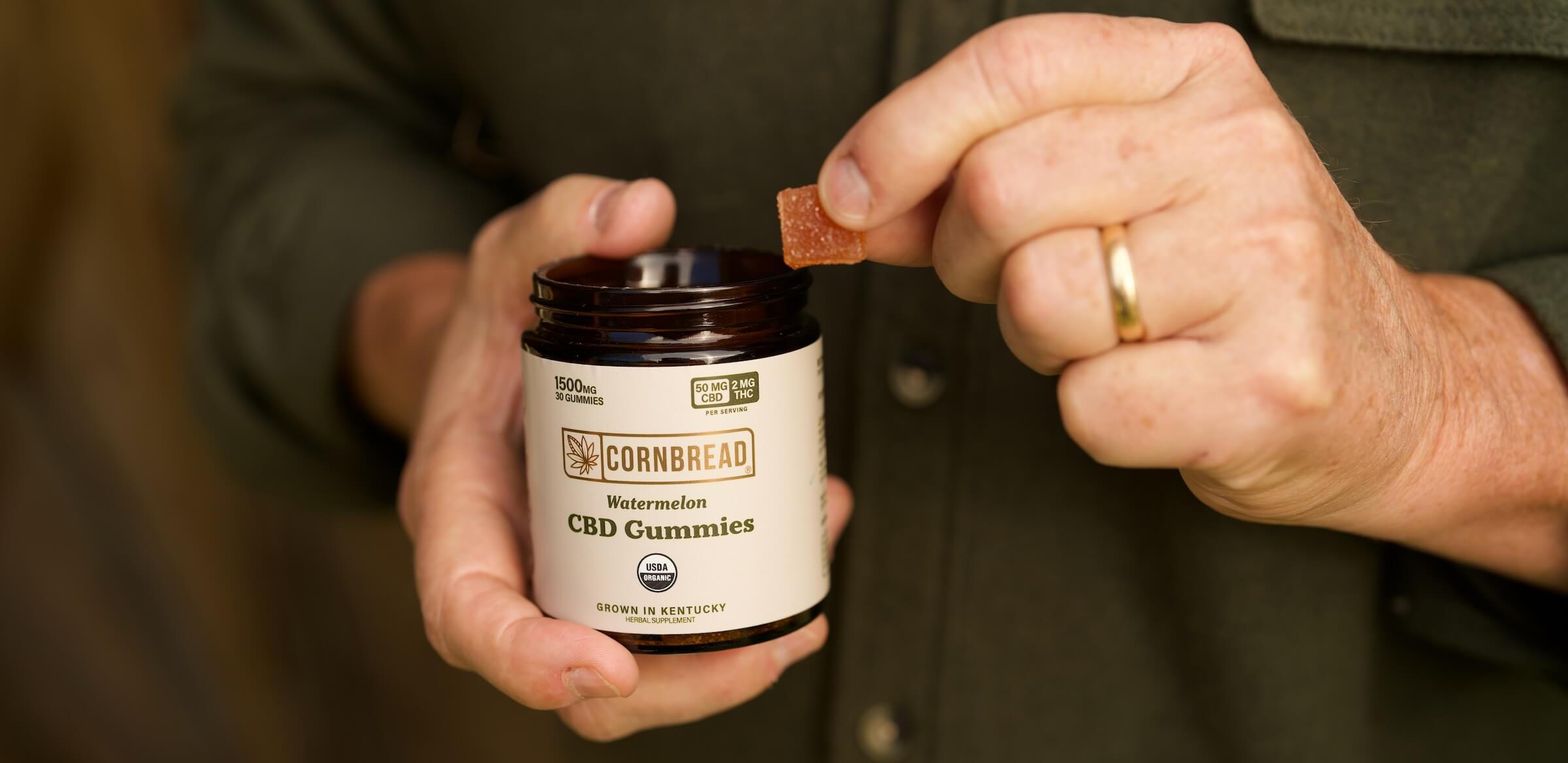 cbd gummies with thc watermelon flavor being taken out of the bottle